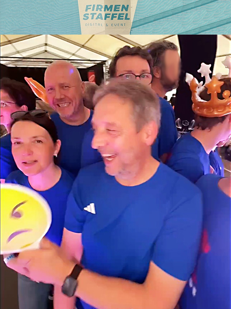 Mitarbeiter der MACON BAU GmbH Magdeburg in blauen Läufershirts auf dem Video-Rondell in lustigen Posen, hier lachend und mit gelbem Smiley
