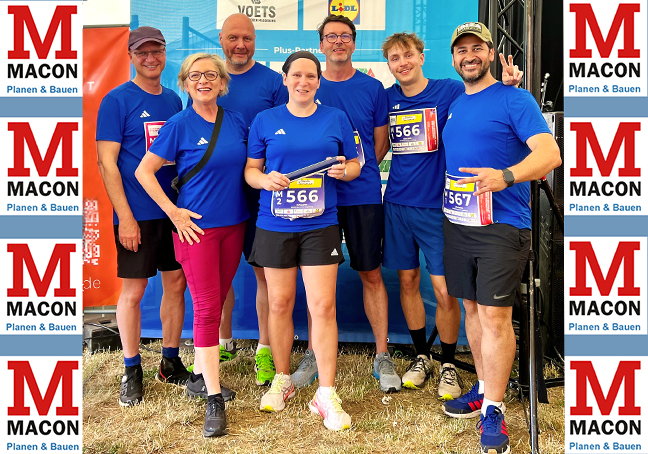 7 Staffelläufer der MACON BAU GmbH stehen vor dem Start in einheitlichen blauen Shirts und Sportkleidung beisammen